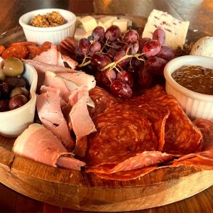 Charcuterie Board featuring fine meats, cheeses, spreads, fruits, nuts and French baguette offered by Napa Kitchen + Bar in Dublin, Ohio.